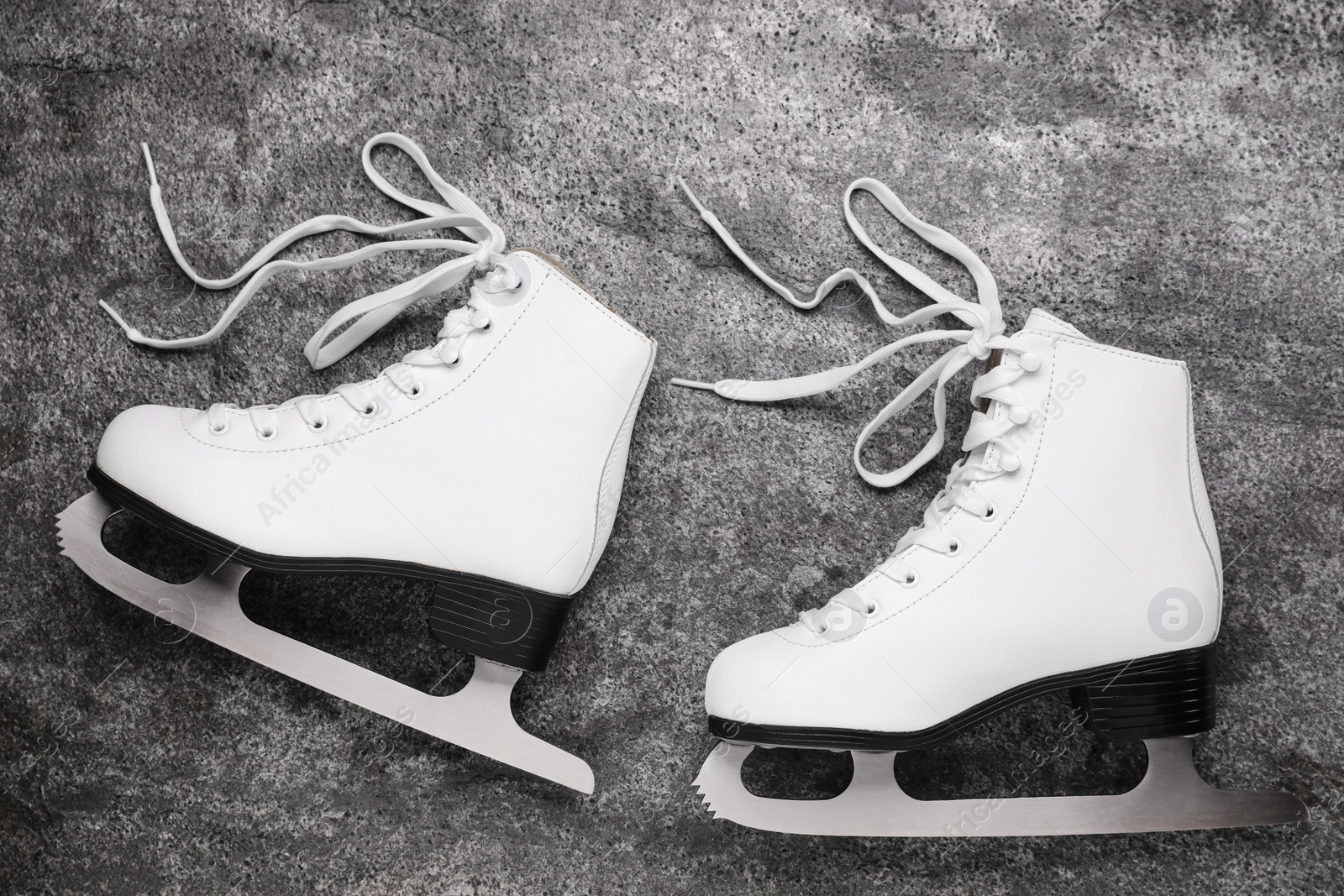 Photo of Pair of white ice skates on grey background, top view