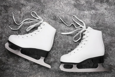 Photo of Pair of white ice skates on grey background, top view