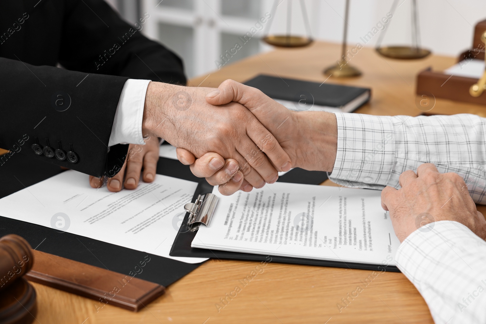 Photo of Lawyer shaking hands with client in office, closeup