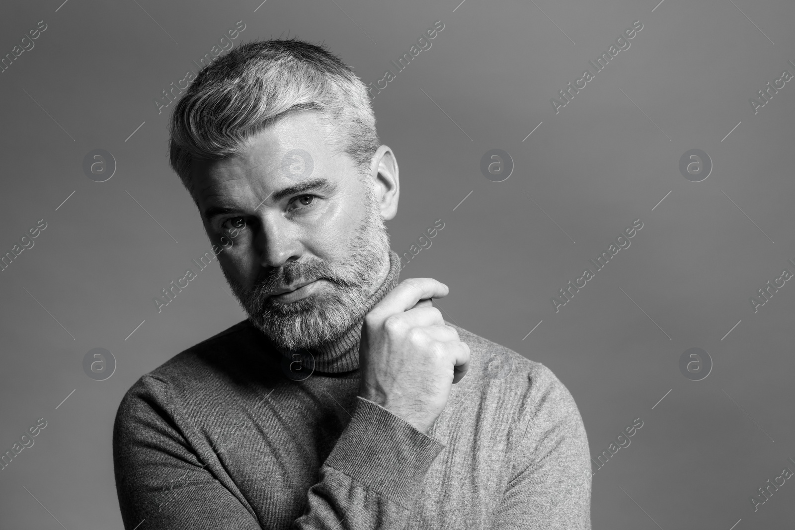 Photo of Portrait of handsome man on grey background, space for text. Black and white effect