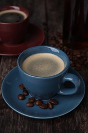 Delicious coffee and beans on wooden table