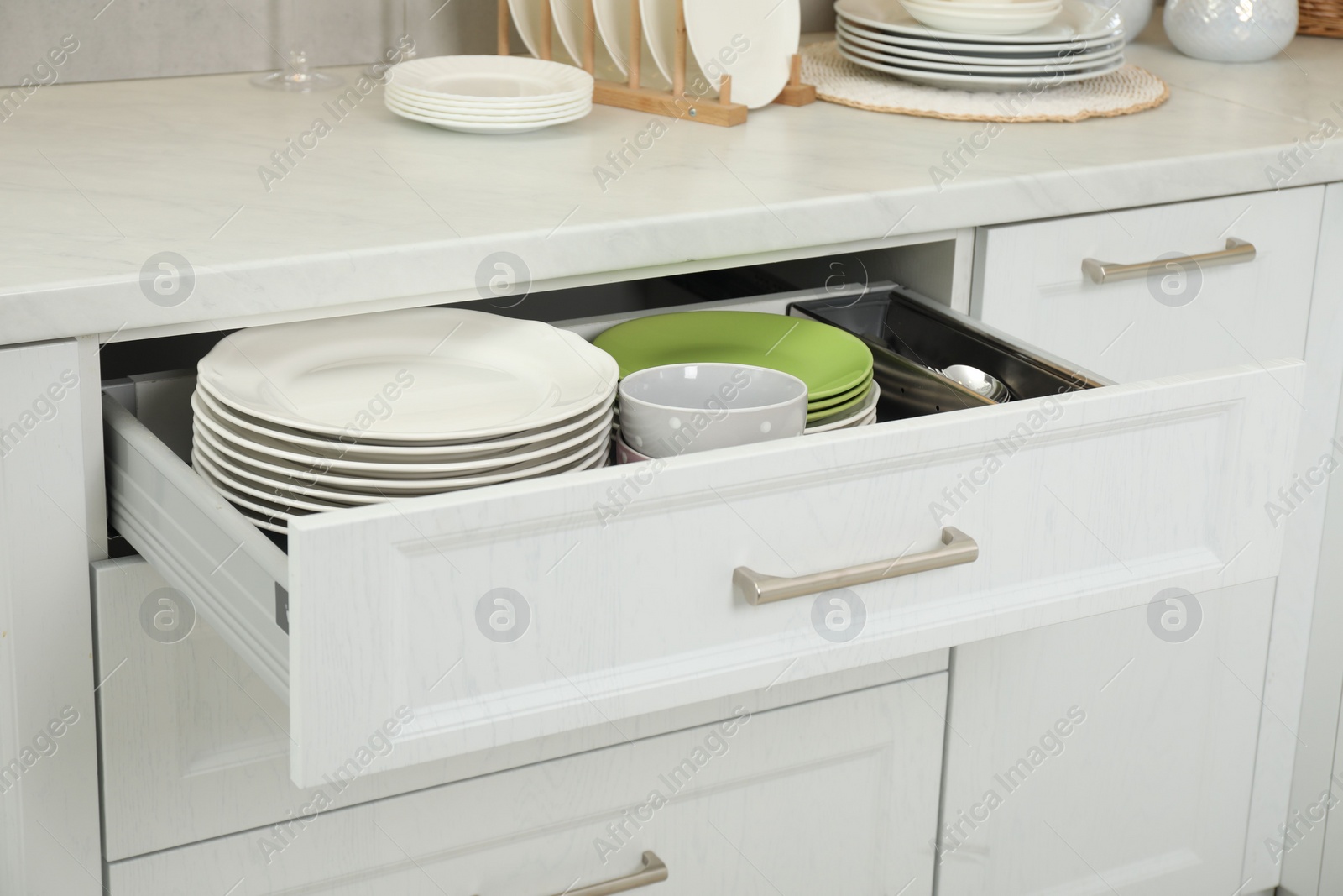 Photo of Clean plates and bowl in drawer indoors