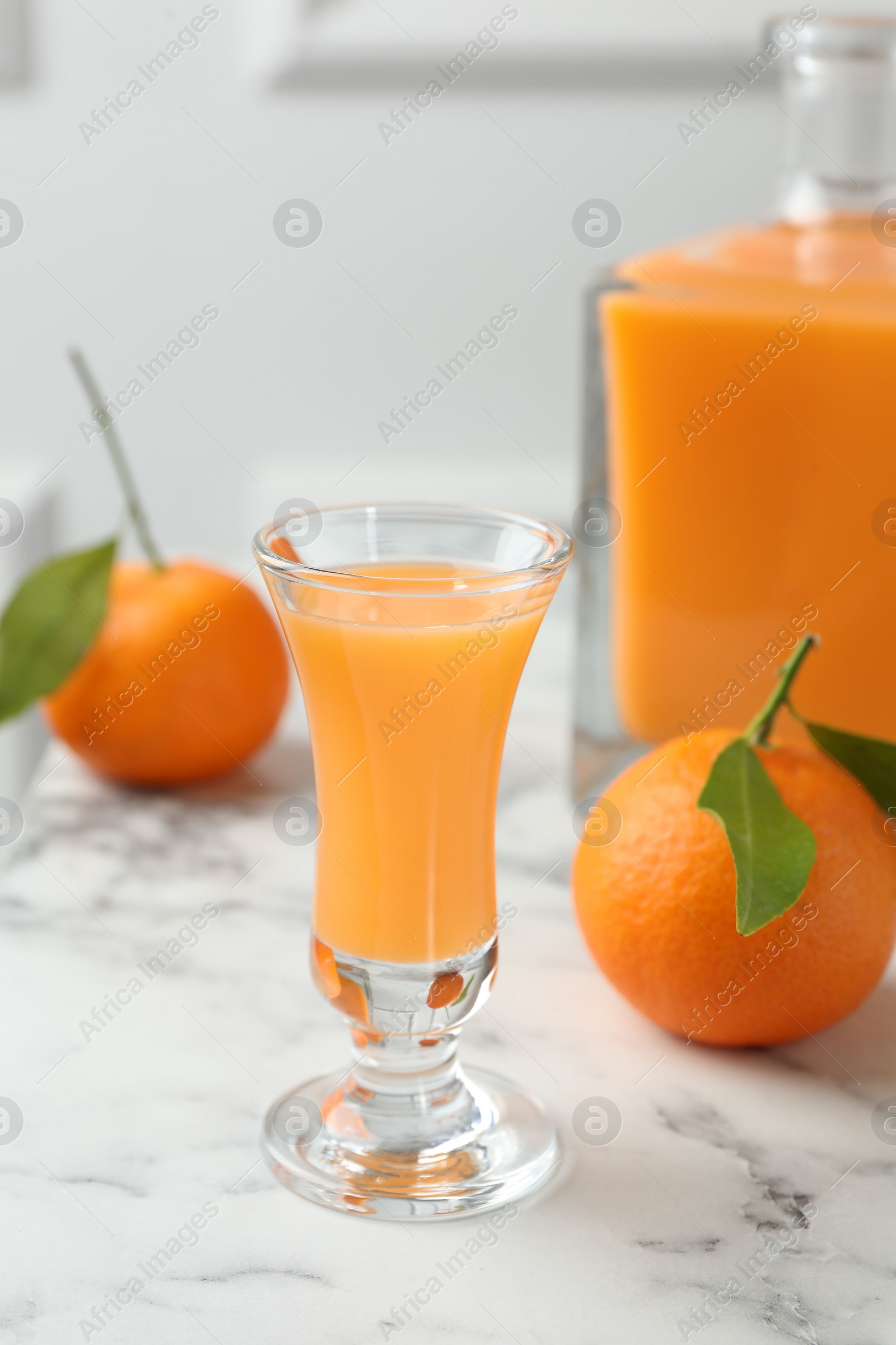 Photo of Delicious tangerine liqueur and fresh fruits on white marble table