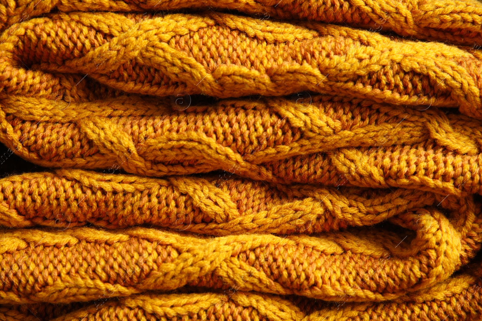 Photo of Soft orange knitted plaid as background, closeup