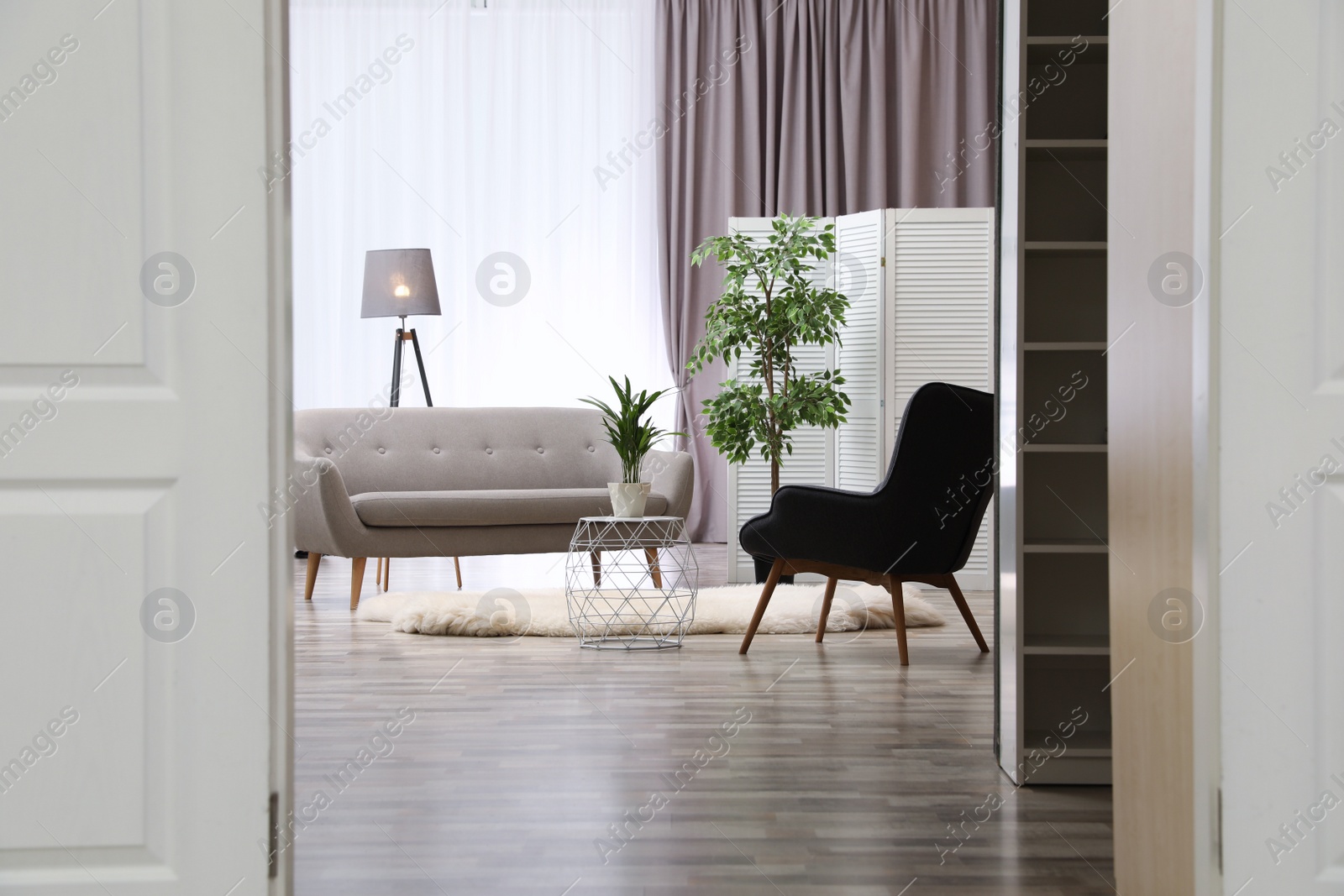 Photo of Stylish room interior, view through open door