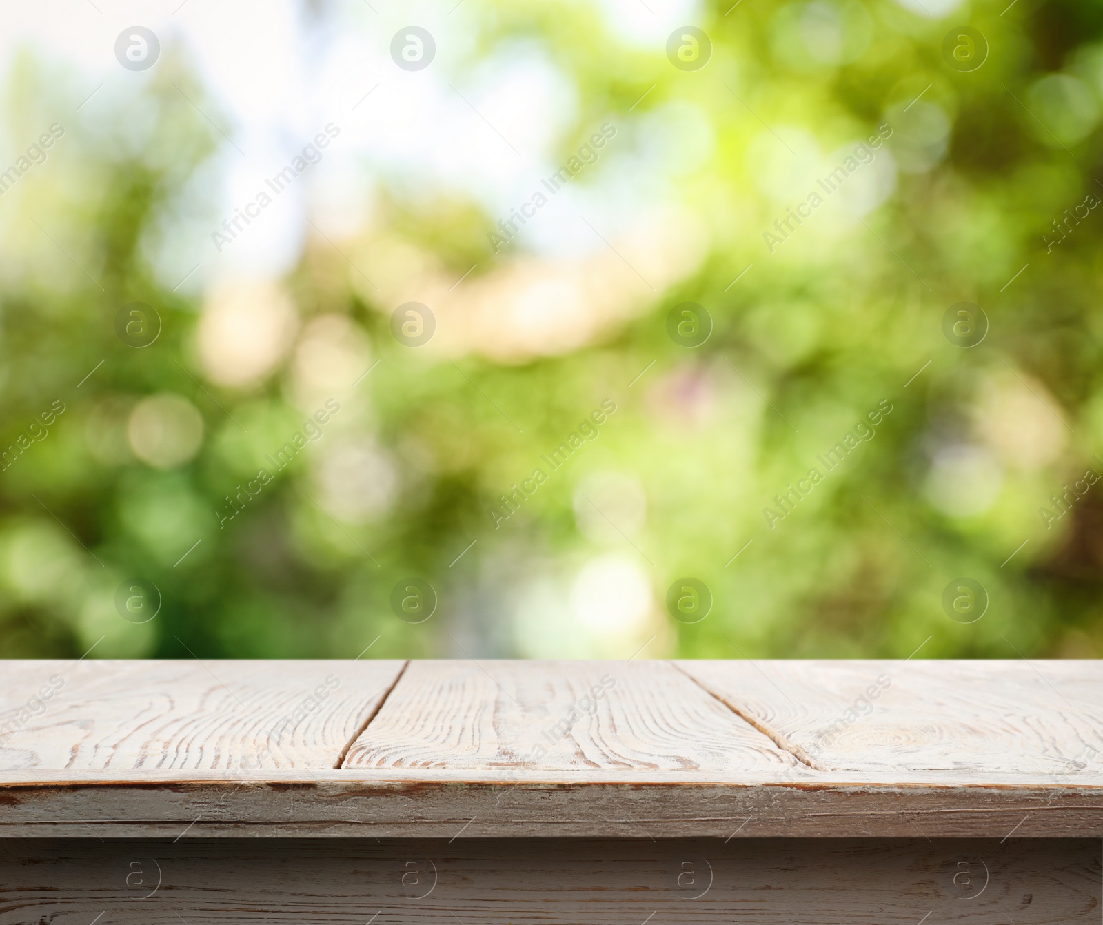 Image of Empty white wooden surface against blurred green background. Space for design