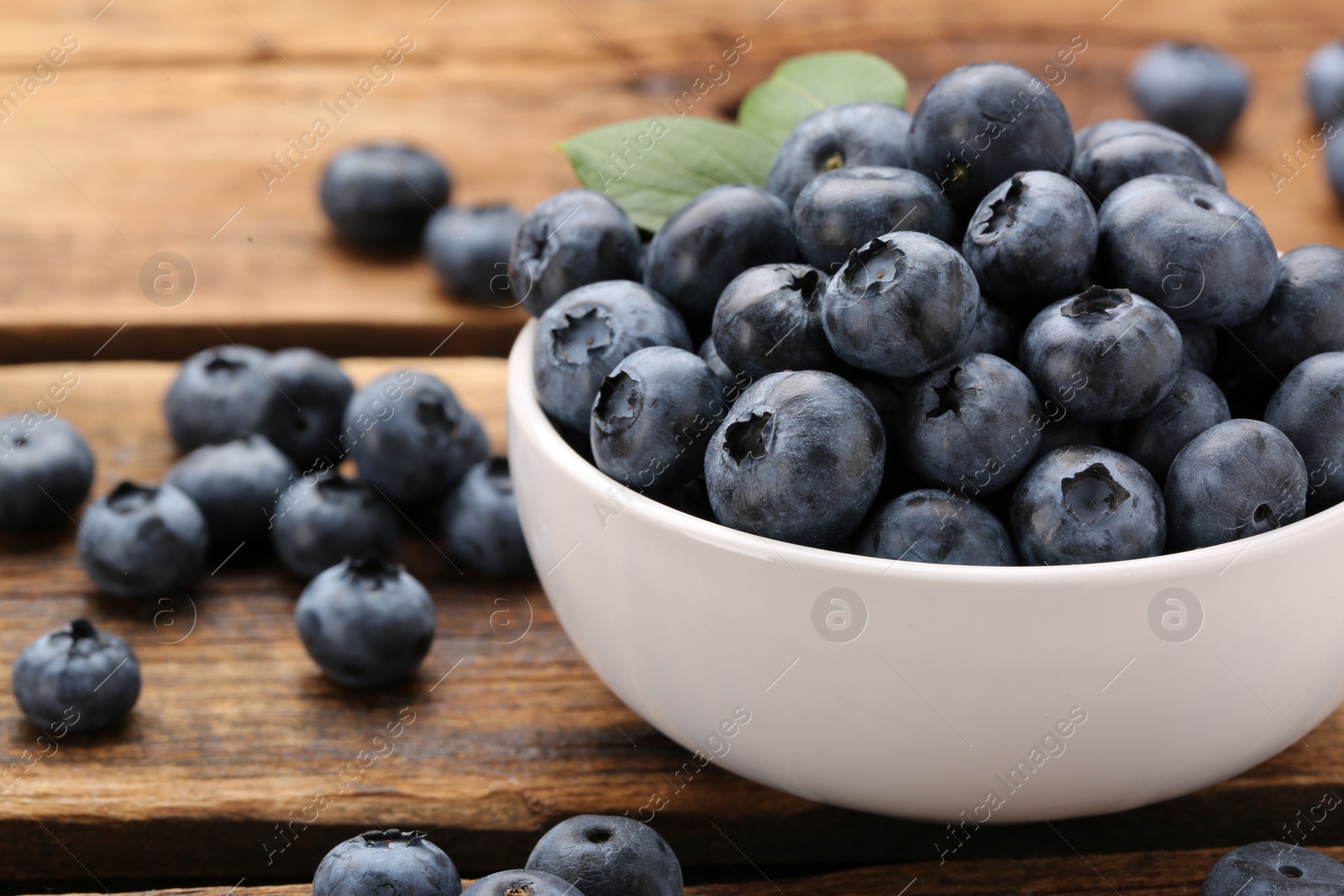 Photo of Tasty fresh blueberries on wooden table, closeup