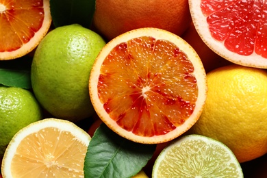 Different citrus fruits as background, top view