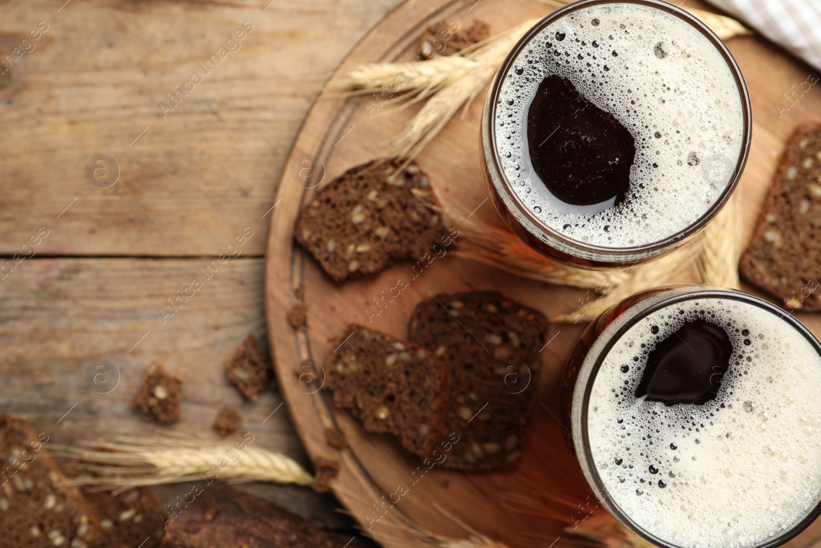 Photo of Delicious kvass, bread and spikes on wooden table, flat lay. Space for text