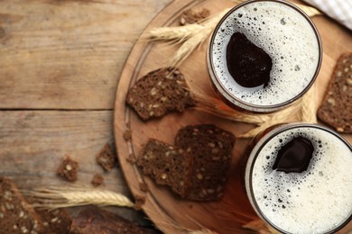 Photo of Delicious kvass, bread and spikes on wooden table, flat lay. Space for text