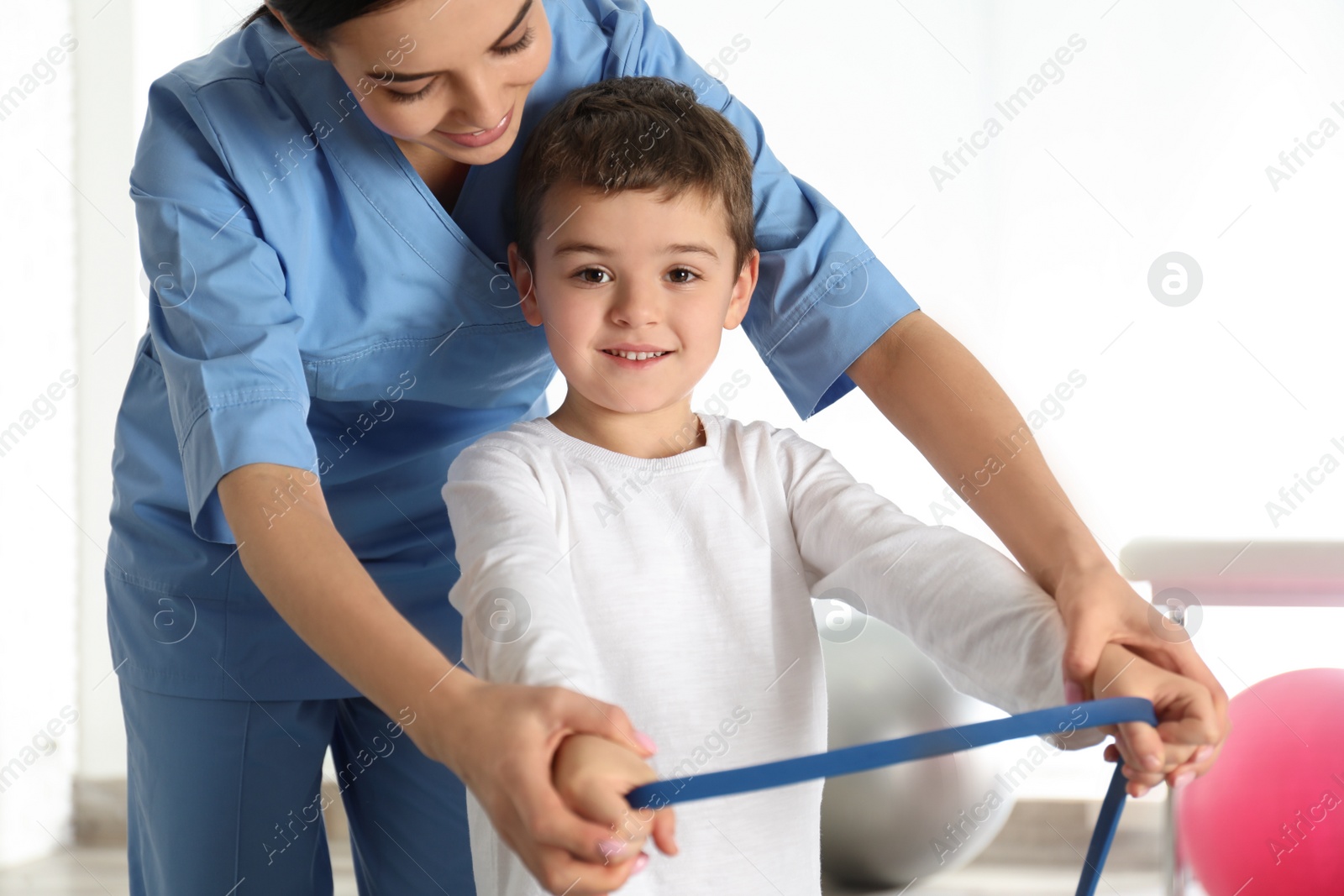 Photo of Orthopedist working with little boy in hospital gym