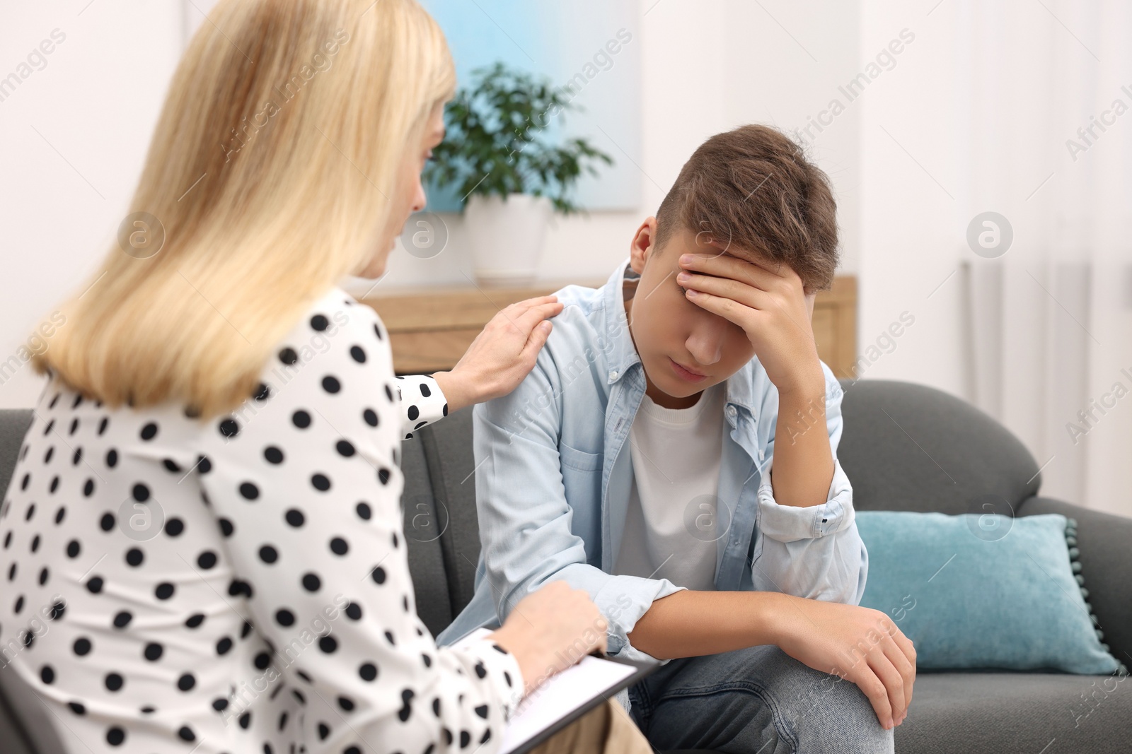 Photo of Psychologist working with teenage boy in office