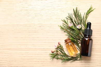 Photo of Flat lay composition with bottles of natural tea tree oil and space for text on wooden background