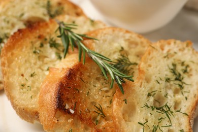 Tasty baguette with garlic and dill on table, closeup