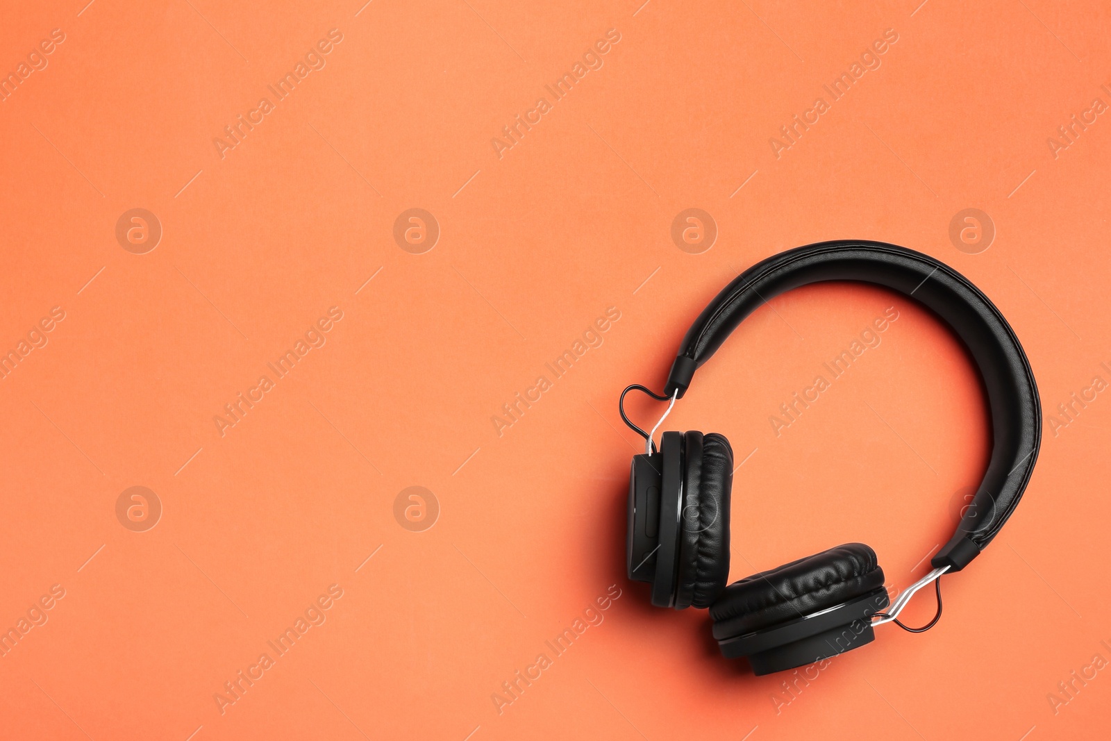 Photo of Stylish headphones on color background, top view. Space for text