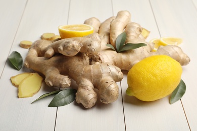 Fresh lemons and ginger on white wooden table