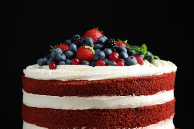 Delicious homemade red velvet cake with fresh berries on black background, closeup