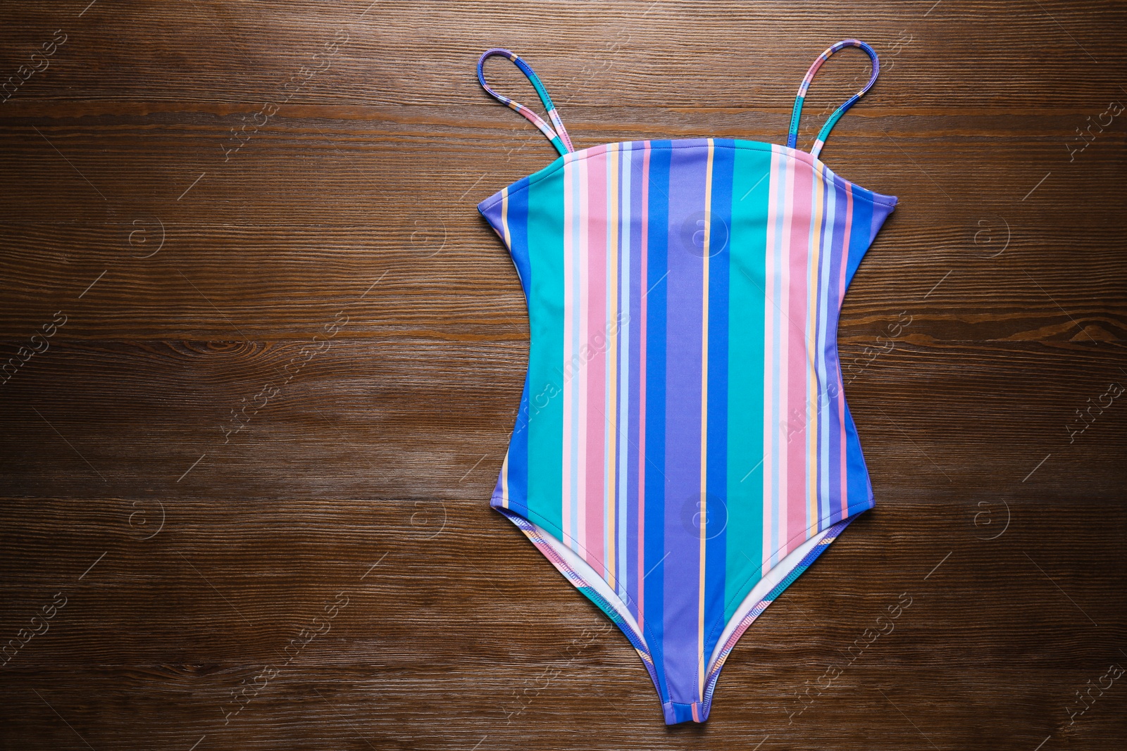 Photo of Beautiful swimsuit on wooden background, top view