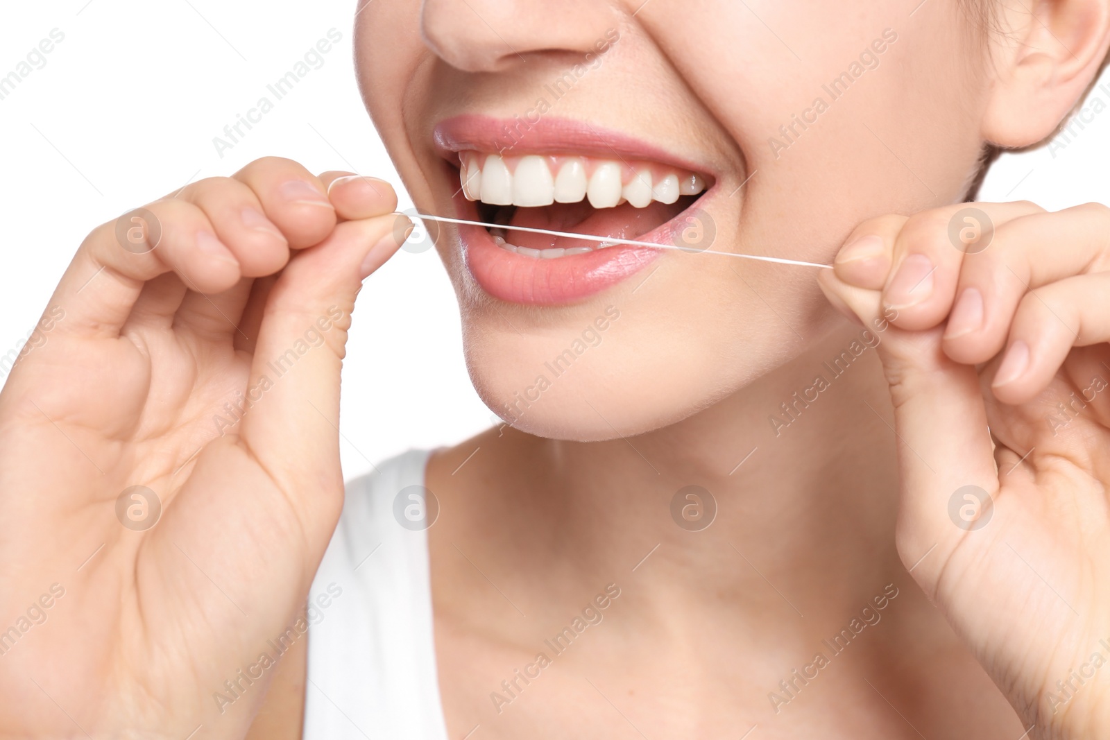 Photo of Young woman flossing her teeth on white background, closeup