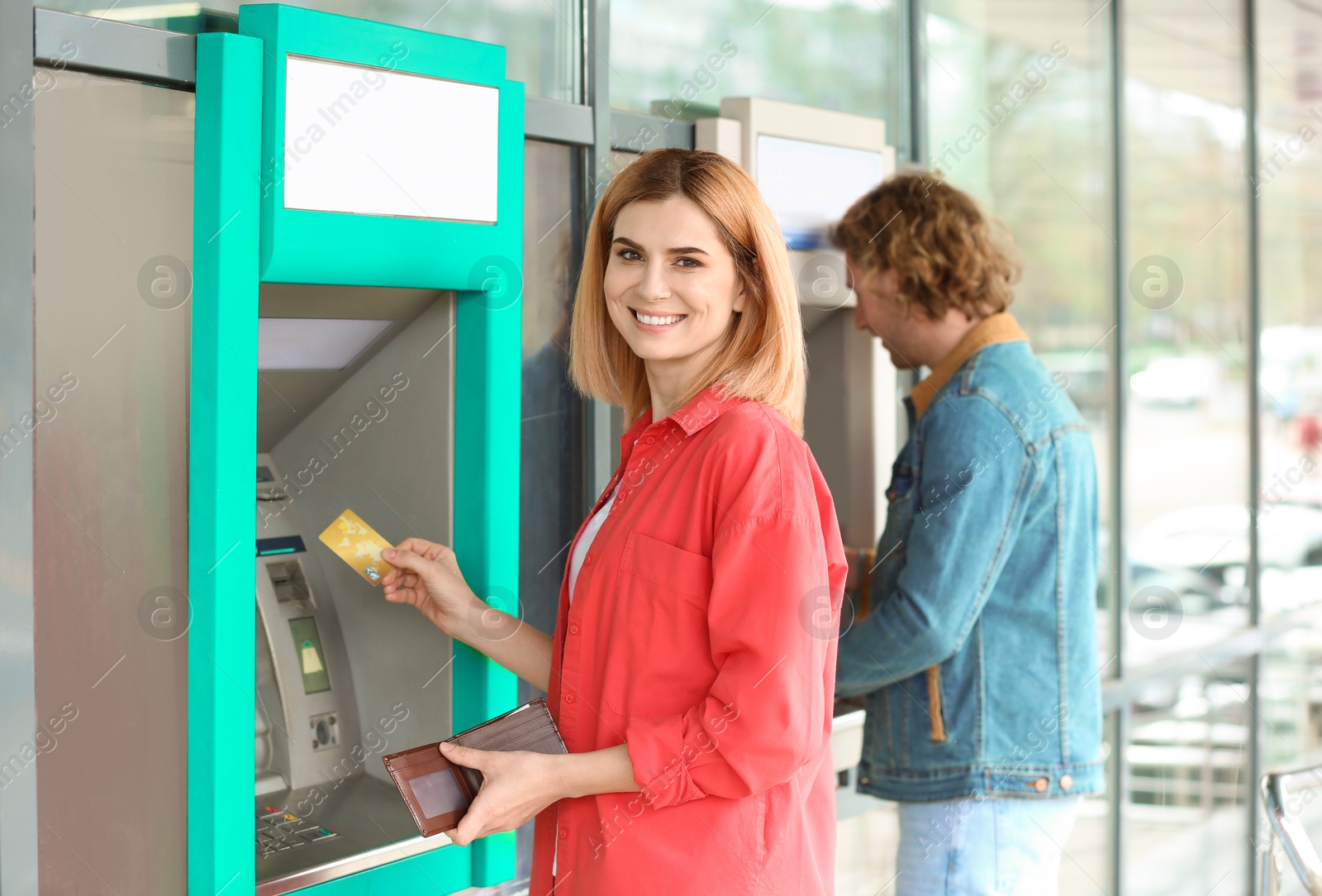 Photo of Beautiful woman with credit card near cash machine outdoors