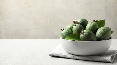 Image of Delicious fresh feijoas in bowl on light grey table, space for text. Banner design