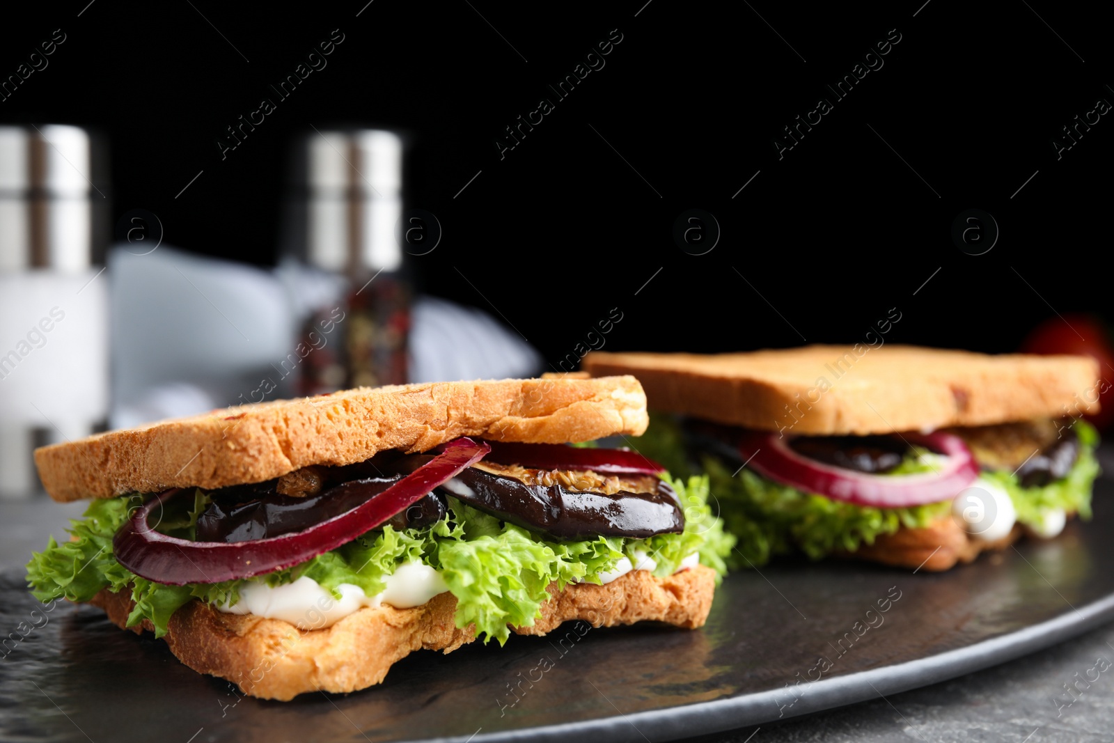 Photo of Delicious eggplant sandwiches on slate board, closeup