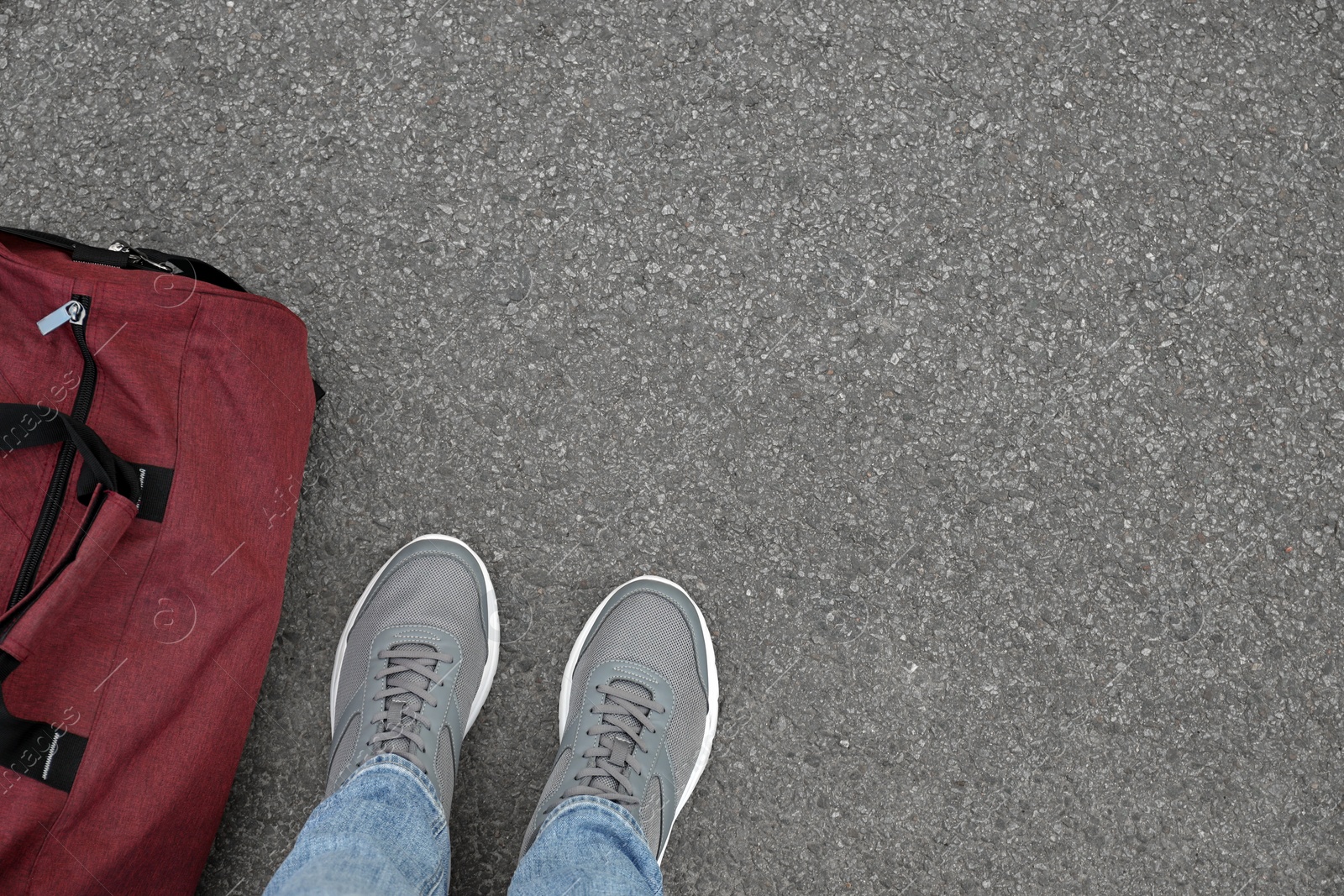 Photo of Man with bag standing on asphalt, top view. Space for text