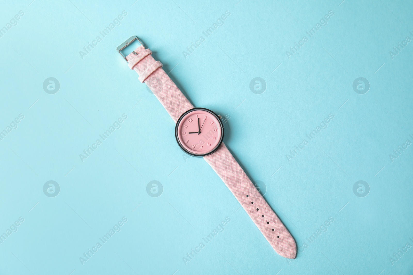 Photo of Stylish wrist watch on color background, top view. Fashion accessory