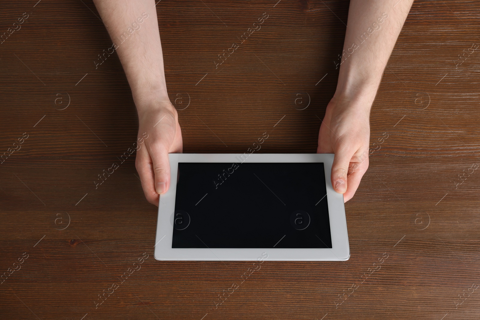 Photo of Man working with tablet at wooden table, top view