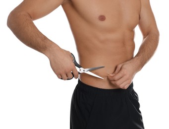 Photo of Fit man with scissors on white background, closeup. Weight loss surgery