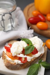 Photo of Delicious sandwich with burrata cheese and tomatoes on table, closeup