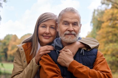 Photo of Portrait of affectionate senior couple in autumn park