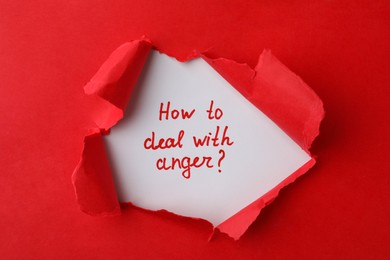 Photo of Inscription How To Deal With Anger? on white background, view through hole in torn red paper