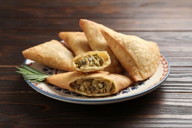 Photo of Fresh delicious crispy samosas served on wooden table