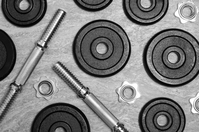 Photo of Flat lay composition with dumbbell parts on gray background