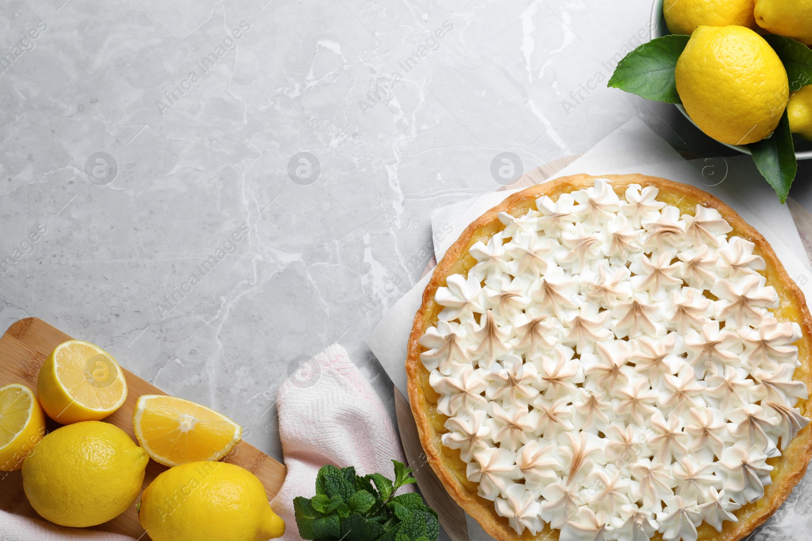 Photo of Flat lay composition with delicious lemon meringue pie on light grey table, space for text