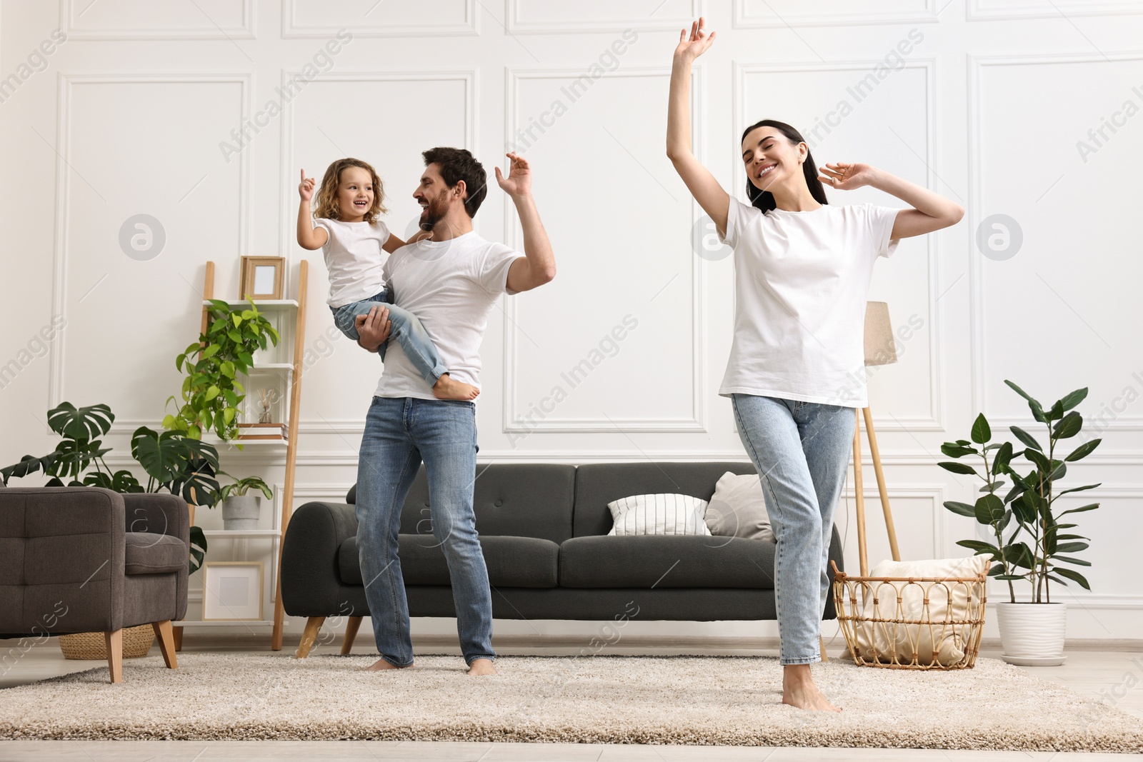 Photo of Happy family dancing and having fun in living room, low angle view