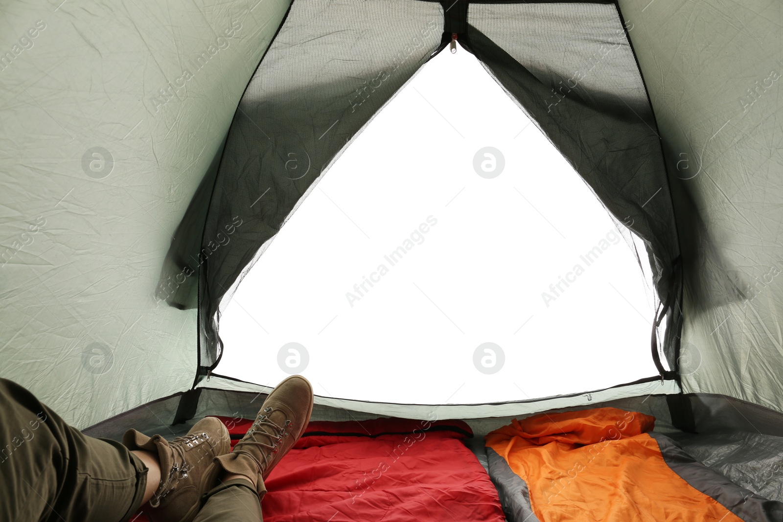 Photo of Closeup of female in camping tent on white background, view from inside