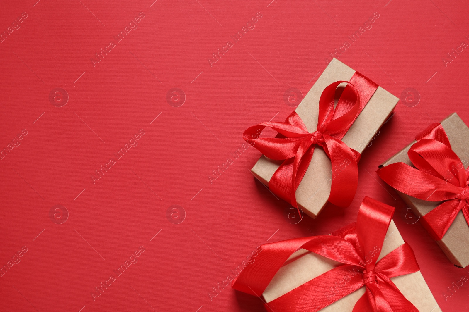 Photo of Beautiful gift boxes on red background, flat lay. Space for text