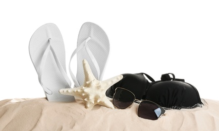 Photo of Different beach accessories on sand against white background