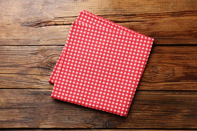 Red checkered tablecloth on wooden table, top view