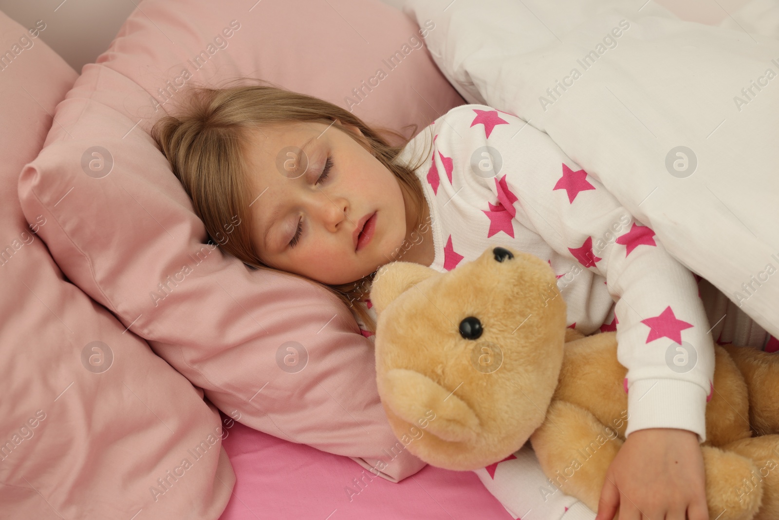 Photo of Little girl snoring while sleeping in bed