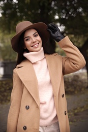 Photo of Young woman wearing stylish clothes in autumn park