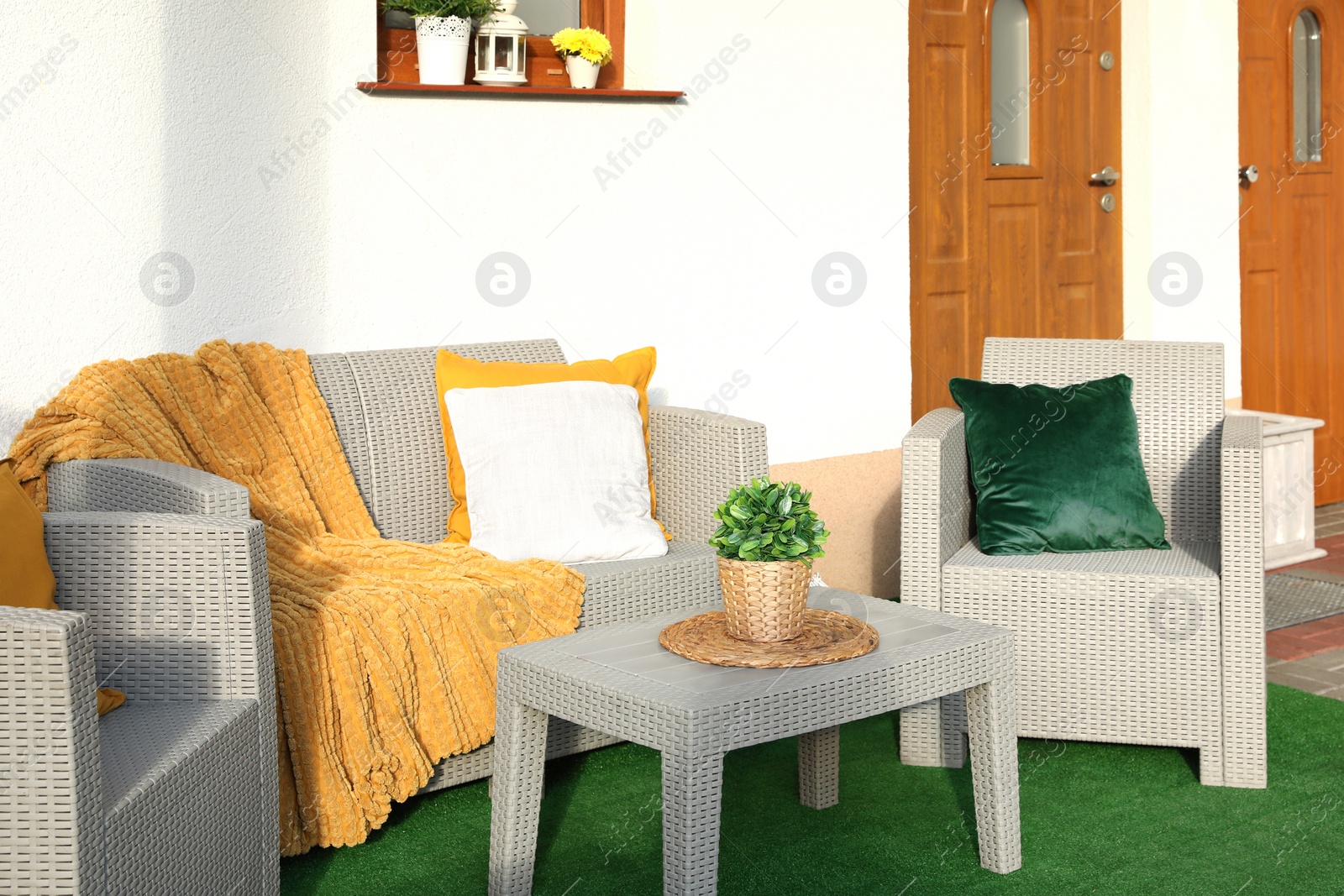 Photo of Beautiful rattan garden furniture, soft pillows, blanket and houseplant outdoors