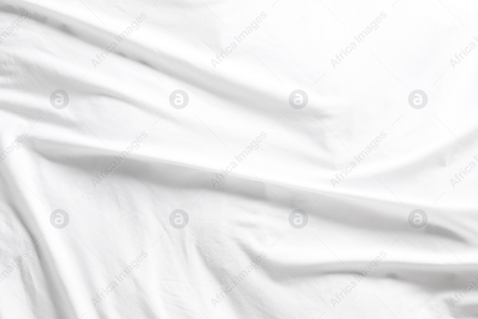 Photo of Crumpled white fabric as background, top view