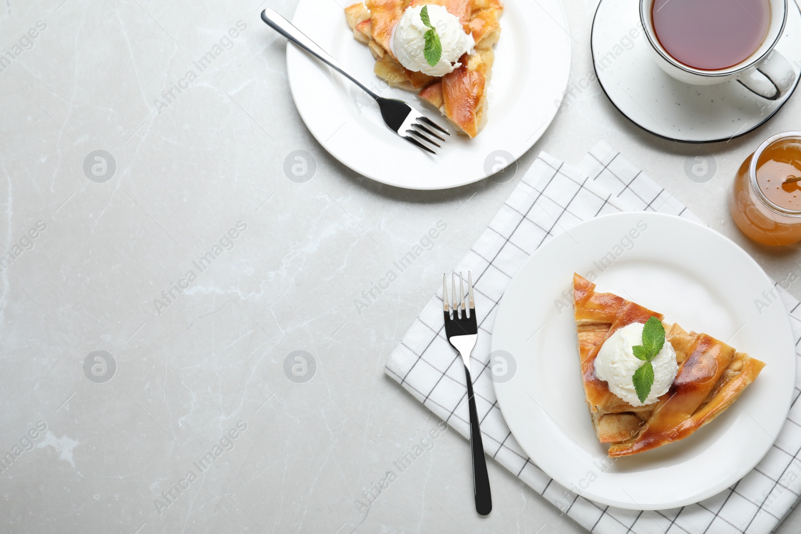 Photo of Slice of traditional apple pie with ice cream served on light marble table, flat lay. Space for text