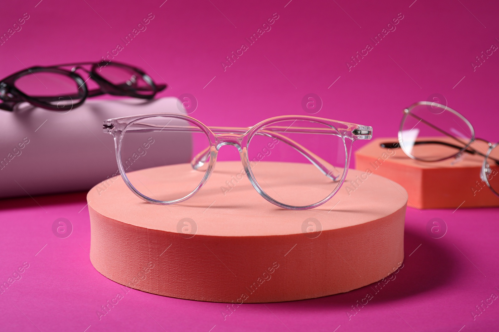 Photo of Stylish presentation of different glasses on pink background, closeup