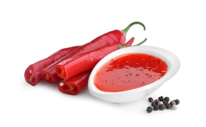 Photo of Spicy chili sauce, peppers and peppercorns isolated on white