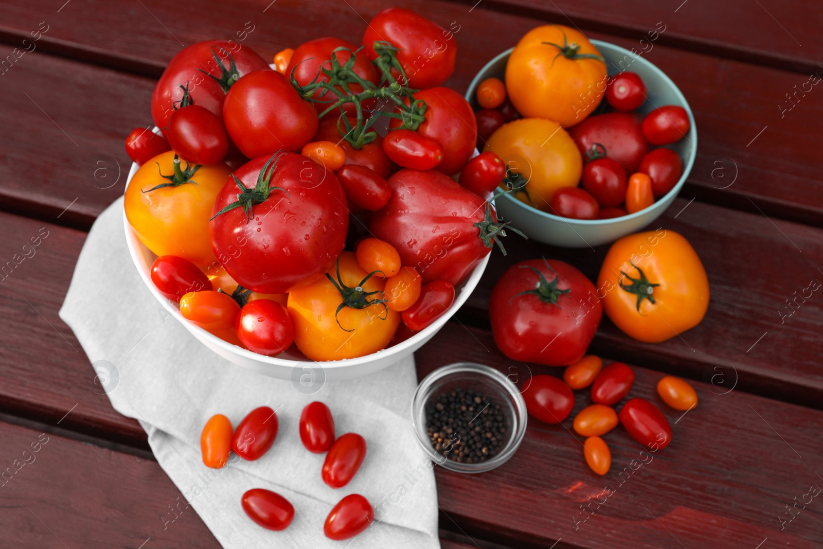 Photo of Bowls with fresh tomatoes and spices on wooden table, flat lay
