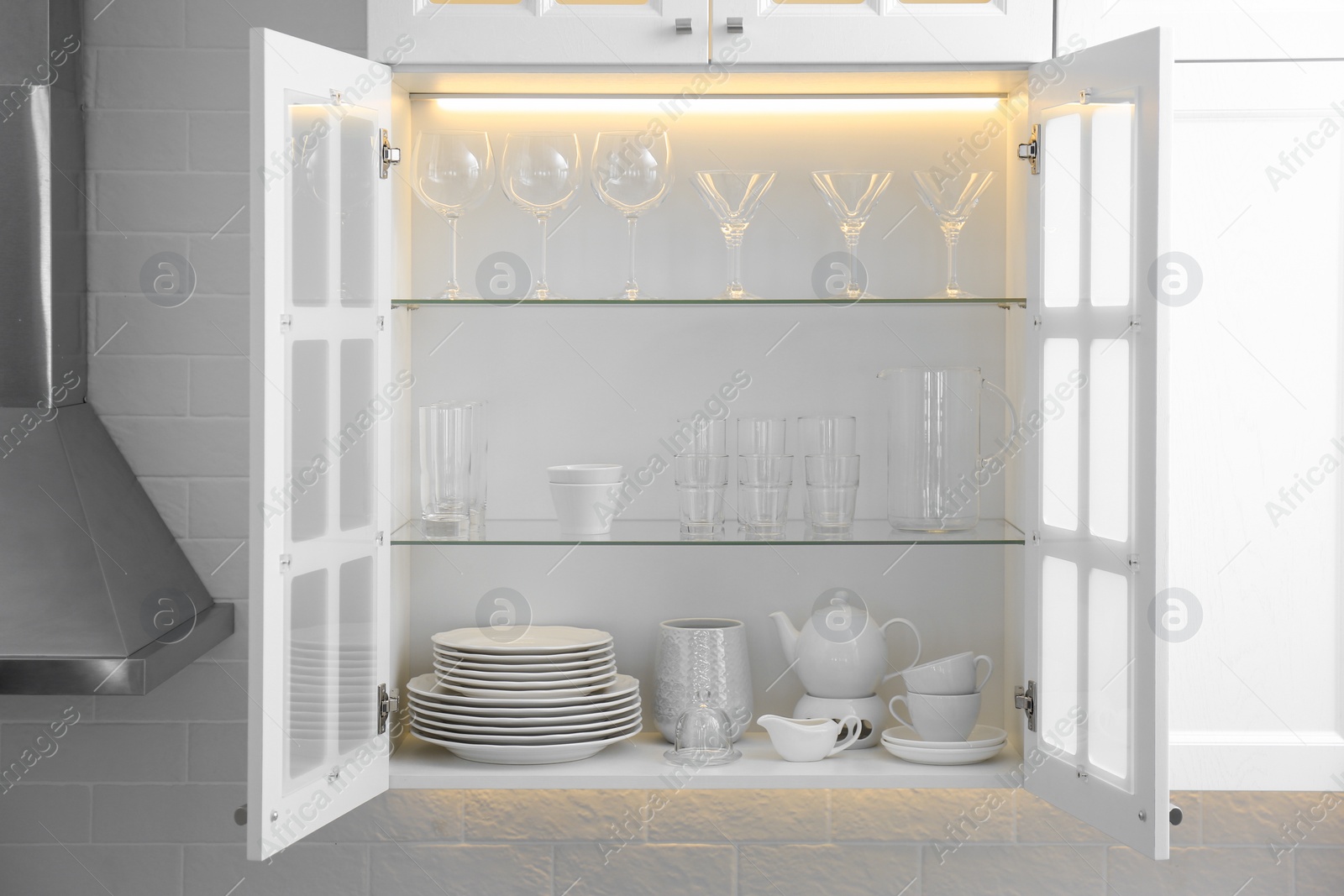 Photo of Cabinet with crockery and glassware. Order in kitchen